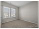 Neutral-toned bedroom featuring a large window offering natural light and plush carpeting at 240 Portrait Way # 87, Indian Trail, NC 28079