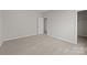 Bedroom with neutral walls and carpet, featuring an open doorway to a closet at 240 Portrait Way # 87, Indian Trail, NC 28079