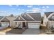Beautiful home with a manicured lawn, covered porch with chairs, and a convenient two-car garage at 240 Portrait Way # 87, Indian Trail, NC 28079