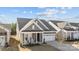 Charming single-Gathering home featuring a covered front porch with rocking chairs and a two-car garage at 240 Portrait Way # 87, Indian Trail, NC 28079