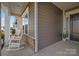 Inviting front porch features rocking chairs, a brick base, and a view of the neighborhood at 240 Portrait Way # 87, Indian Trail, NC 28079