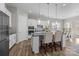 Well-equipped kitchen with island seating, stainless steel appliances, white cabinetry, and hardwood floors at 240 Portrait Way # 87, Indian Trail, NC 28079