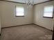 A basic, empty room with carpet, two windows, and neutral walls at 3510 Flint Dr, Statesville, NC 28677