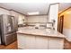 Well-lit kitchen featuring an island, stainless steel refrigerator, and white cabinetry at 3510 Flint Dr, Statesville, NC 28677