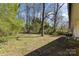 A spacious backyard featuring green grass, mature trees, and full perimeter fencing at 3843 Foxford Pl, Charlotte, NC 28215