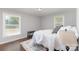 Serene bedroom featuring neutral colors, hardwood floors, and two large windows at 3843 Foxford Pl, Charlotte, NC 28215