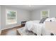 Serene bedroom featuring neutral colors, hardwood floors, and two large windows at 3843 Foxford Pl, Charlotte, NC 28215