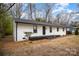 White brick ranch house with a black roof and small front porch at 3843 Foxford Pl, Charlotte, NC 28215