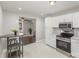 Bright kitchen featuring white cabinets, stainless steel appliances, and tile floors at 3843 Foxford Pl, Charlotte, NC 28215