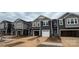 New townhouses with 2-car garages, neutral siding, and landscaping at 7228 Hodges Meadow Ln, Charlotte, NC 28213