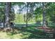 Lush backyard featuring mature trees and a rustic seating area at 7740 Robinson Church Rd, Charlotte, NC 28215