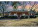 Brick ranch house with a covered porch and landscaped yard at 7740 Robinson Church Rd, Charlotte, NC 28215
