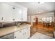 Kitchen boasts white cabinets, light countertops, and a view into the dining area at 7740 Robinson Church Rd, Charlotte, NC 28215