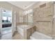 Luxurious bathroom featuring separate tub and shower, chandelier, and tiled surround at 1007 Orchid Ln, Fort Mill, SC 29707