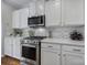 White kitchen featuring stainless steel appliances, granite counters and tile backsplash at 1007 Orchid Ln, Fort Mill, SC 29707