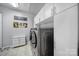 Modern laundry room with front-loading washer and dryer, ample storage, and tile flooring at 1007 Orchid Ln, Fort Mill, SC 29707