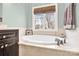 Bathroom with a luxurious soaking tub and natural light from the window at 107 E Cold Hollow Farms Dr, Mooresville, NC 28117