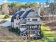 Aerial view of a spacious two-story home with a deck overlooking the landscaped backyard and surrounding woods at 107 E Cold Hollow Farms Dr, Mooresville, NC 28117