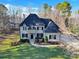 Stunning two-story home with dark shutters, a stone entrance, a well-manicured lawn, and mature trees at 107 E Cold Hollow Farms Dr, Mooresville, NC 28117