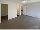 Bright bedroom with grey carpet, ceiling fan, and multiple doors at 10945 Carmel Crossing Rd, Charlotte, NC 28226