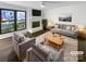 Virtually staged living room featuring a fireplace and ample natural light at 10945 Carmel Crossing Rd, Charlotte, NC 28226