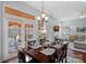 Bright dining room featuring a wood table, chandelier, and access to a screened-in porch with outdoor seating at 11414 Coreopsis Rd, Charlotte, NC 28213