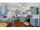 Well-lit kitchen featuring blue cabinets, hardwood floors, modern appliances, and plenty of counter space at 11414 Coreopsis Rd, Charlotte, NC 28213