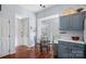 Bright breakfast area with large windows, hardwood floors, blue cabinets, and stainless steel appliances at 11414 Coreopsis Rd, Charlotte, NC 28213