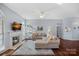 Cozy living room featuring a fireplace, large windows, hardwood floors, and a comfortable sofa at 11414 Coreopsis Rd, Charlotte, NC 28213