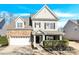 Brick and beige two-story house with a white garage door and landscaping at 1227 Mountain Laurel Ct, Matthews, NC 28104