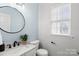 Modern powder room with marble vanity and black accents at 13443 Norseman Ln, Huntersville, NC 28078