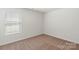 Well-lit bedroom with neutral walls and carpeting, featuring a window with blinds at 1524 Doran Ter, Richburg, SC 29729