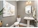 Elegant powder room with pedestal sink, gold accents, and modern art at 1575 Riverwalk Pkwy, Rock Hill, SC 29730