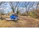 Large backyard with a gravel firepit area and blue Adirondack chairs offers a serene outdoor retreat at 19705 S Ferry St, Cornelius, NC 28031