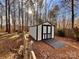 White and black storage shed with a convenient ramp at 203 Shane Dr, Mount Holly, NC 28120