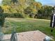 Backyard patio and large lawn surrounded by mature trees creates a private outdoor oasis at 3818 Carl Parmer Dr, Harrisburg, NC 28075