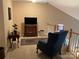 Upstairs bonus room featuring a TV, chair, and a view of the staircase at 3818 Carl Parmer Dr, Harrisburg, NC 28075