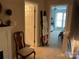 Hallway view with open doorways and a chair next to a fireplace at 3818 Carl Parmer Dr, Harrisburg, NC 28075