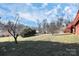 A great view of the property's large backyard featuring mature trees and the red deck of the home at 4029 Wild Nursery Ct, Charlotte, NC 28215