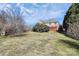 A great view of the property's large backyard featuring mature trees and the red deck of the home at 4029 Wild Nursery Ct, Charlotte, NC 28215