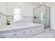 Bathroom featuring a tub, glass-enclosed shower, and a window at 4029 Wild Nursery Ct, Charlotte, NC 28215