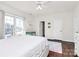 Bright bedroom featuring hardwood floors, a ceiling fan, and large windows with bright natural light at 4029 Wild Nursery Ct, Charlotte, NC 28215