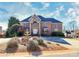 Elegant brick home with a stone facade and arched entrance, complemented by a decorative fountain at 4029 Wild Nursery Ct, Charlotte, NC 28215