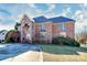 Elegant brick home with a stone facade and arched entrance, surrounded by lush greenery and a well-maintained lawn at 4029 Wild Nursery Ct, Charlotte, NC 28215