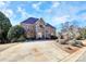 Elegant brick home with a stone facade and arched entrance, complemented by mature trees and a well-manicured lawn at 4029 Wild Nursery Ct, Charlotte, NC 28215