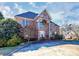 Elegant brick home with a stone facade and arched entrance, complemented by a lush green lawn at 4029 Wild Nursery Ct, Charlotte, NC 28215