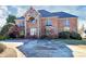 Elegant brick home featuring a stone facade, arched entryway, and a spacious driveway leading to the front entrance at 4029 Wild Nursery Ct, Charlotte, NC 28215