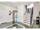 Inviting foyer with black marble flooring, elegant staircase with wrought iron railing, and arched doorway at 4029 Wild Nursery Ct, Charlotte, NC 28215