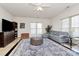 Bright living room features tile floors, a leather sectional, and a large window for ample natural light at 4029 Wild Nursery Ct, Charlotte, NC 28215