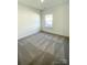 Bright bedroom with grey carpet and large window at 412 Catawba Ave, Davidson, NC 28036